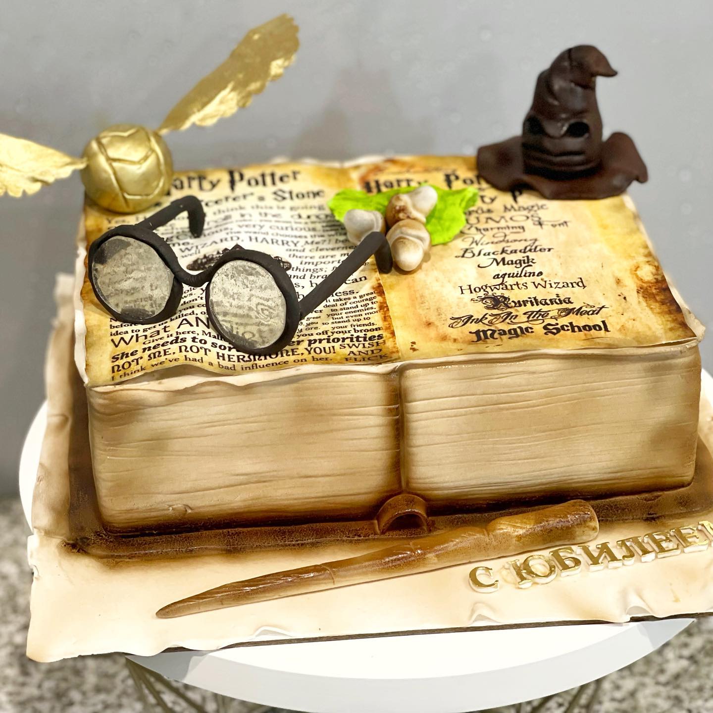 Торт в виде раскрытой книги Гарри Поттера с очками и шляпой